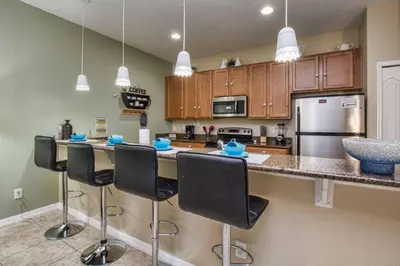 a kitchen with a counter with bar stools at Pvt Splashpool, Bbq Grill, Close To Parks-3057Pp in Kissimmee