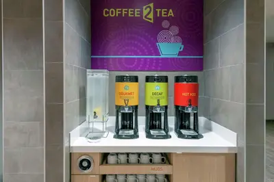 a shelf with four coffee cups on a wall at Home2 Suites By Hilton Orlando Near Universal in Orlando
