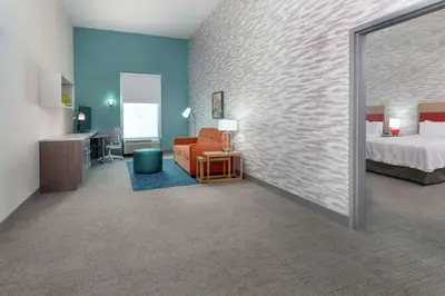a hotel room with a bedroom and a bed at Home2 Suites By Hilton Orlando Near Universal in Orlando