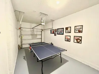a ping pong table is in a room with a wall at Home Away From Home in Kissimmee
