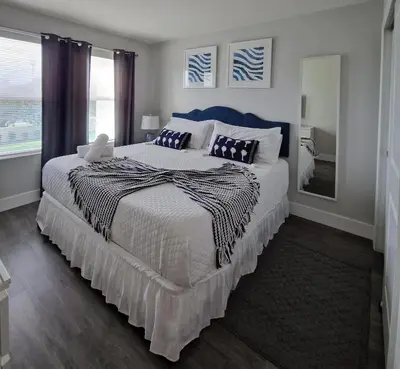 a bedroom with a large bed with a blue headboard at Home Away From Home in Kissimmee