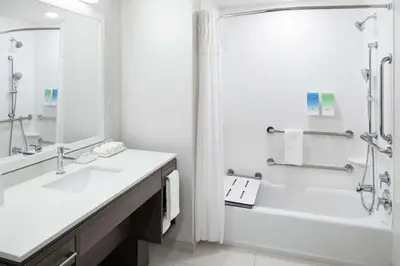 a bathroom with a tub and a sink and a shower at Home2 Suites By Hilton Orlando Airport in Orlando