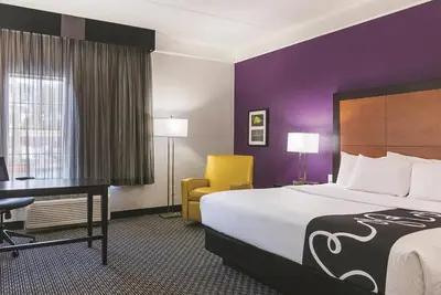 a hotel room with a bed and a desk at La Quinta by Wyndham Orlando Airport - On Property Food Trucks & Free Airport Shuttle! in Orlando