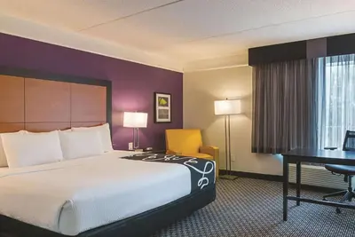 a hotel room with a large bed and a desk at La Quinta by Wyndham Orlando Airport - On Property Food Trucks & Free Airport Shuttle! in Orlando