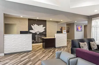 a lobby with a waiting room with a purple couch at La Quinta by Wyndham Orlando Airport - On Property Food Trucks & Free Airport Shuttle! in Orlando
