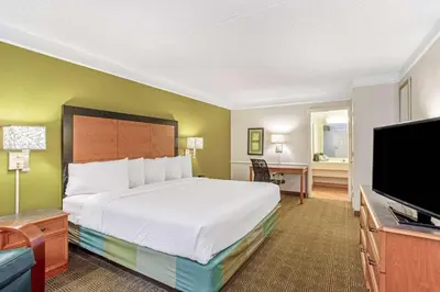 a hotel room with a bed and a flat screen tv at La Quinta Inn by Wyndham Orlando Airport West in Orlando