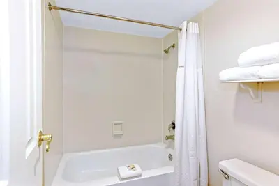 a bathroom with a shower and a white tub at La Quinta Inn by Wyndham Orlando Airport West in Orlando