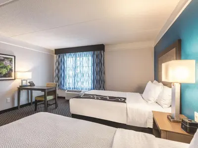 a hotel room with two beds and a desk at La Quinta by Wyndham Orlando Lake Mary in Lake Mary