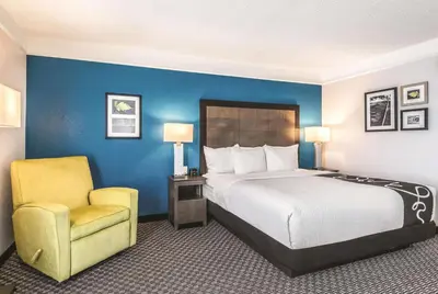 a hotel room with a bed and a chair at La Quinta by Wyndham Orlando Lake Mary in Lake Mary