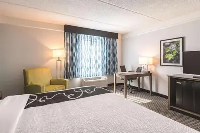 a hotel room with a bed and a desk and chair at La Quinta by Wyndham Orlando Lake Mary in Lake Mary