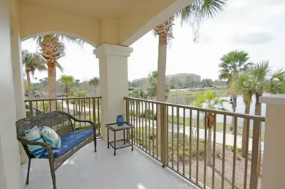 a porch with a bench and palm trees at Modern Vacation Apartment with a Lake View in Orlando