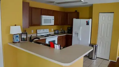a kitchen with a counter and a white refrigerator at Beautiful Hollywood style home next to Disney in Kissimmee