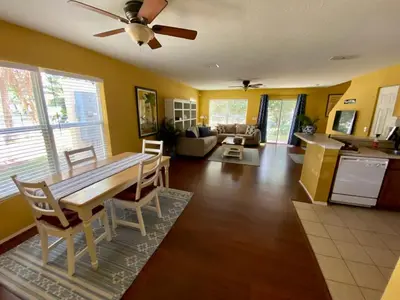 a kitchen and living room with a table and chairs at Beautiful Hollywood style home next to Disney in Kissimmee
