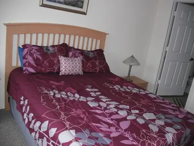 a bed with a purple comforter and pillows at Venetian Bay Villa 4 Bedroom Townhouse - Near Disney in Kissimmee