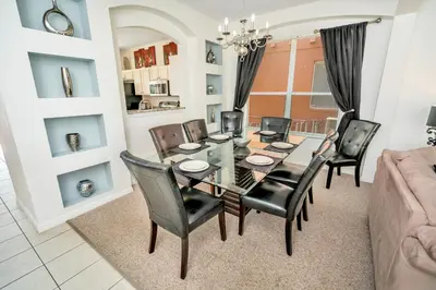 a dining room with a table and chairs at Disney Dream with Hot Tub, Pool, Xbox, Games Room, Lakeview, 10 min to Disney, Clubhouse in Kissimmee