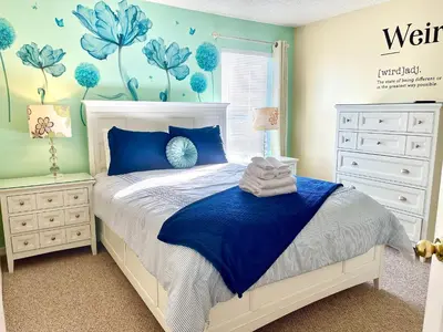 a bedroom with a bed with blue flowers on the wall at Disney Dream with Hot Tub, Pool, Xbox, Games Room, Lakeview, 10 min to Disney, Clubhouse in Kissimmee