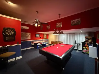a pool table in a room with red walls at Seasons Villa 6 bedrooms, 4 masters and water view in Kissimmee