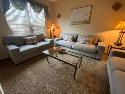 a living room with a couch and a table at Seasons Villa 6 bedrooms, 4 masters and water view in Kissimmee