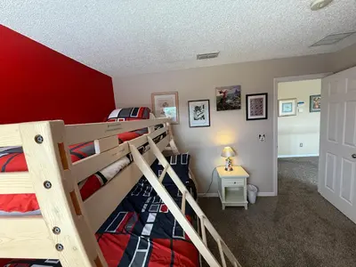 a bedroom with two bunk beds and a red wall at The Villa at Terra Verde in Kissimmee