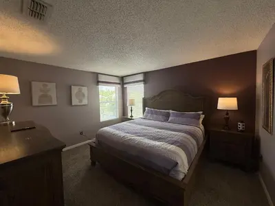 a bedroom with a bed with purple pillows and a window at The Villa at Terra Verde in Kissimmee