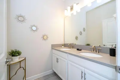 a bathroom with two sinks and a large mirror at Stunning 5 Bd Home w/ Pool Close to Disney 4822 in Kissimmee