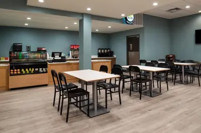 a waiting room with tables and chairs in a restaurant at Holiday Inn & Suites Orlando - I-Drive - Theme Parks by IHG in Orlando