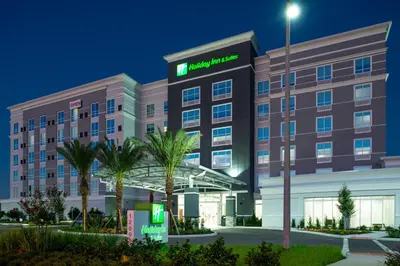 an exterior view of a hotel at night at Holiday Inn & Suites Orlando - I-Drive - Theme Parks by IHG in Orlando