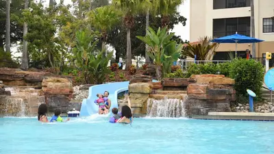 a group of children playing in a water slide at a resort at Holiday Inn Club Vacations At Orange Lake Resort in Orlando