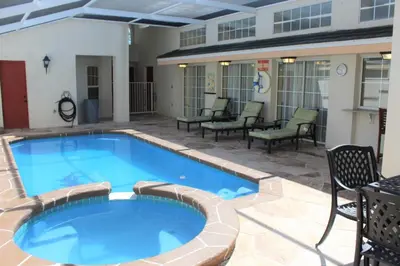 a large blue pool with chairs and chairs around it at Lindfields Reserve #267170 Villa in Kissimmee