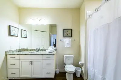 a bathroom with a toilet and a sink and a mirror at Lucaya Village Resort Townhome Unit 14 Townhouse in Orlando