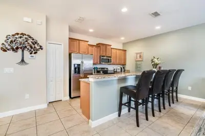 a kitchen with a bar with black stools at Cuban Palm Townhouse #275805 Townhouse in Kissimmee