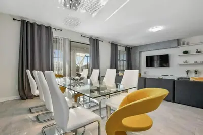 a dining room with a glass table and white chairs at 2901FS - Amazing 8 bedroom at Storey Lake in Kissimmee