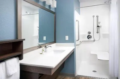 a bathroom with a sink and a shower at Woodspring Suites Orlando International Drive in Orlando