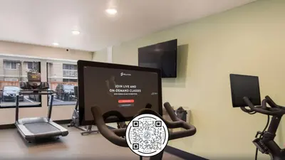 a room with a gym with a monitor and exercise equipment at Woodspring Suites Orlando International Drive in Orlando
