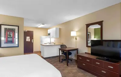 a hotel room with a bed and a desk and a kitchen at Extended Stay America Suites - Orlando - Altamonte Springs in Orlando