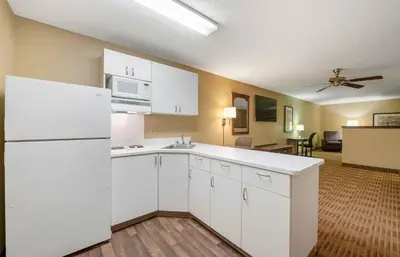 a kitchen with white appliances and a living room at Extended Stay America Suites - Orlando - Lake Mary - 1036 Greenwood Blvd in Lake Mary