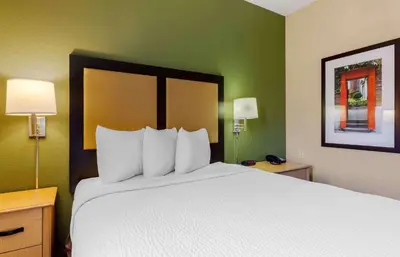 a hotel room with a large bed with white pillows at Extended Stay America Select Suites - Orlando - Lake Mary - 1040 Greenwood Blvd in Lake Mary