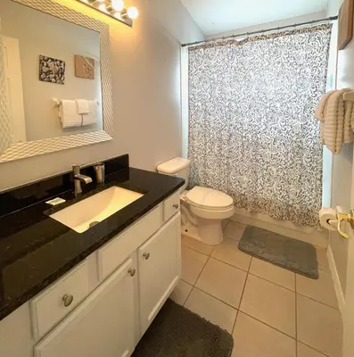 a bathroom with a sink and a toilet and a mirror at Cinderellas Castle in Kissimmee