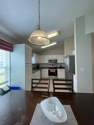 a kitchen with a wooden table with a bowl on the floor at Cinderellas Castle in Kissimmee
