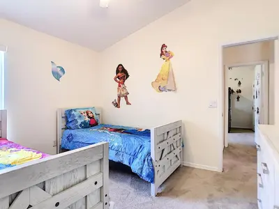 a bedroom with two beds and paintings on the wall at Cinderellas Castle in Kissimmee
