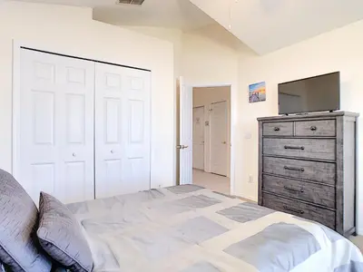 a bedroom with a bed and a dresser with a television at Cinderellas Castle in Kissimmee