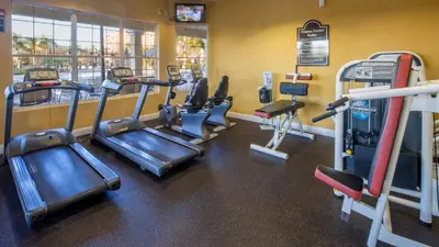 a gym with several tread machines in a room at Chantilly Condo - closer to Disney and Universal in Orlando