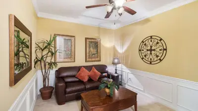 a living room with a couch and a table at Merlyns Magic Condo - closer to Disney in Orlando