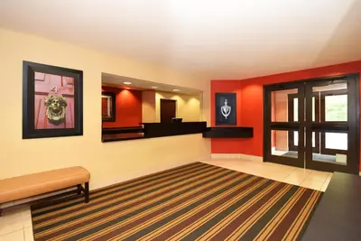 a waiting room with red walls and a mirror at Extended Stay America Suites - Orlando - Orlando Theme Parks - Major Blvd in Orlando