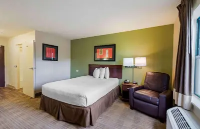 a hotel room with a bed and a chair at Extended Stay America Select Suites - Orlando - Maitland - 1760 Pembrook Dr in Orlando