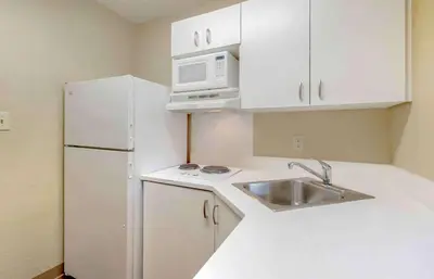 a kitchen with a sink and a white refrigerator at Extended Stay America Select Suites - Orlando - Maitland - 1760 Pembrook Dr in Orlando