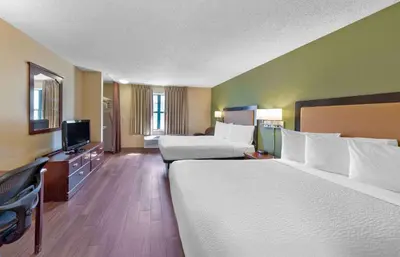 a hotel room with two beds and a flat screen tv at Extended Stay America Select Suites - Orlando - Maitland - 1760 Pembrook Dr in Orlando