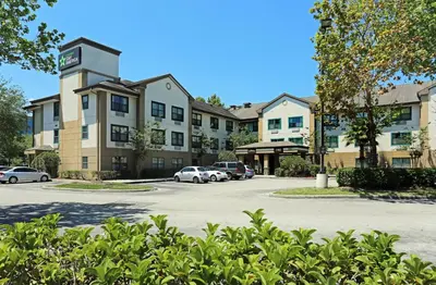 a building with cars parked in a parking lot at Extended Stay America Select Suites - Orlando - Maitland - 1760 Pembrook Dr in Orlando