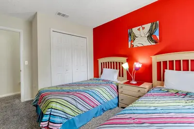 two beds in a room with red walls at Emerald Delight 3 bed townhome near Disney in Kissimmee