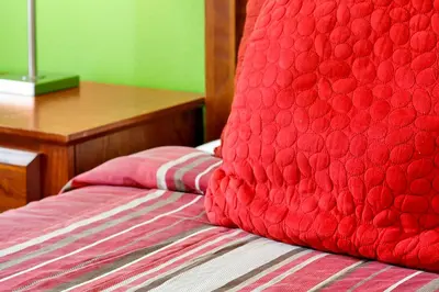 a red bed with a red pillow on top of it at Emerald Delight 3 bed townhome near Disney in Kissimmee